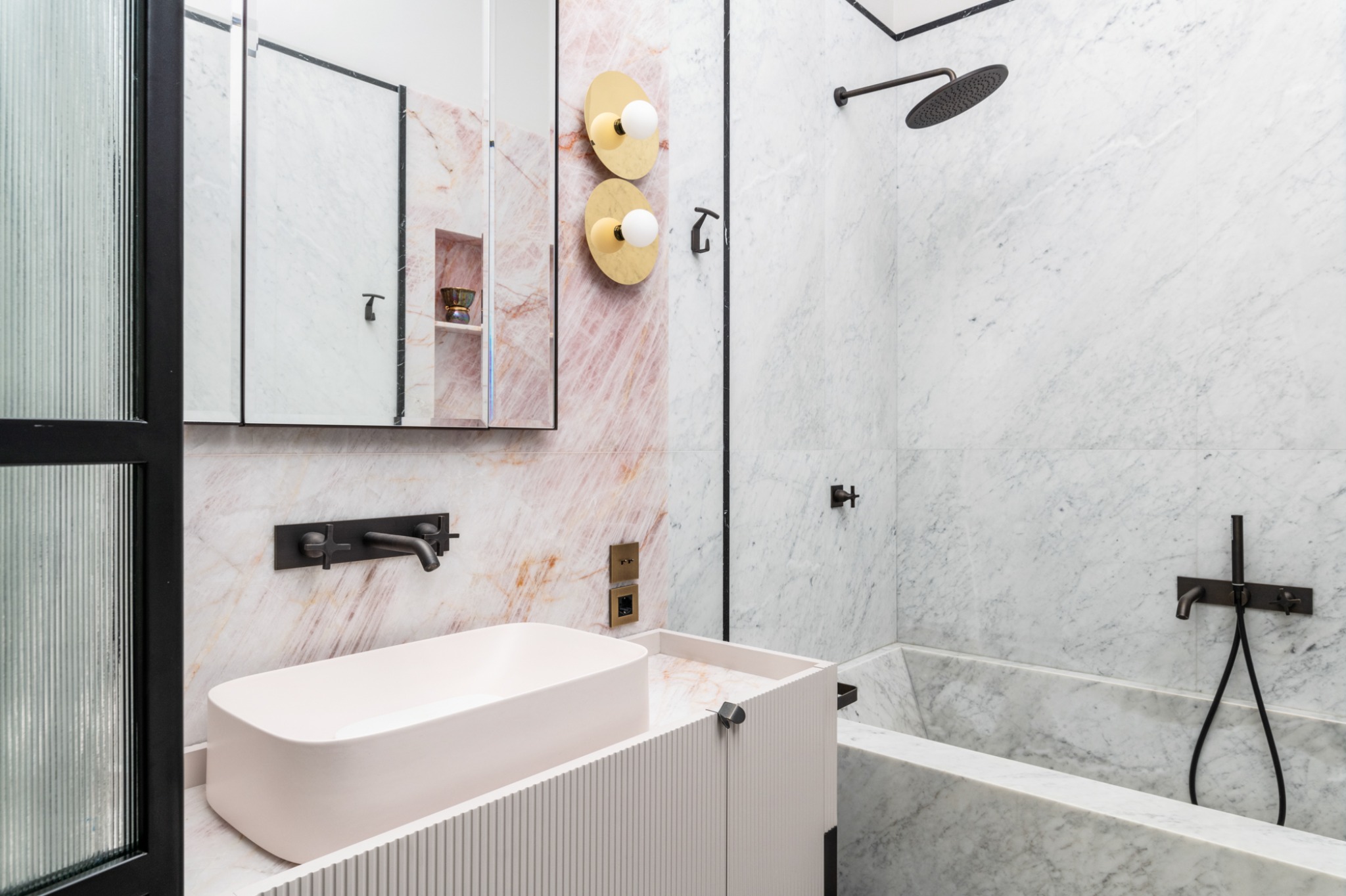 Bathroom in white and pink marble with washbasin and bathtub